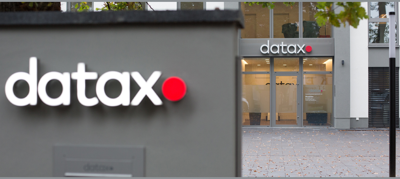 Der Eingangsbereich von außen - Datax Logo über der Eingangstür und das Logo über dem Briefkasten.