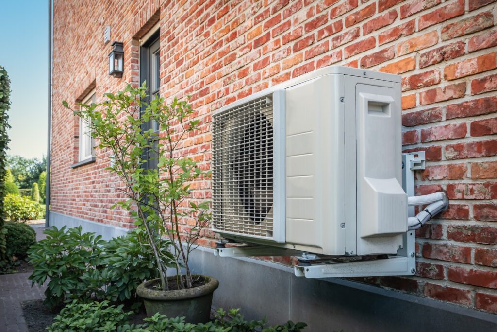 Moderne Wärmepumpe an einem sanierten Einfamilienhaus als förderfähige Maßnahme