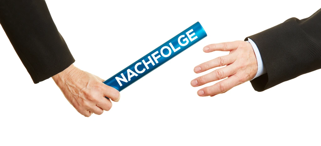 Bild von zwei Händen, die einen Stab mit der Beschriftung “Nachfolge” überreichen, was auf eine einvernehmliche Unternehmensnachfolge hinweist.
